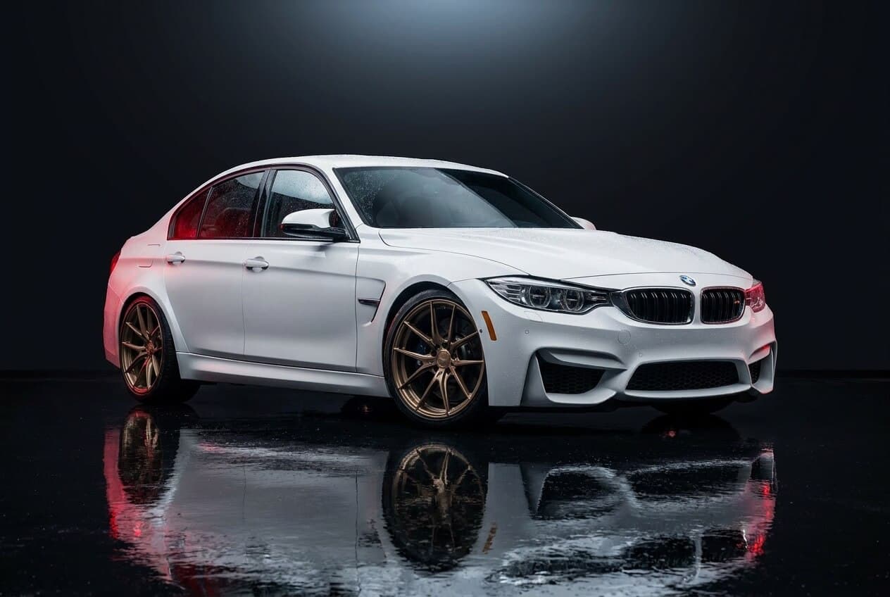 Photoreal render of an Alpine White BMW M3 sedan on bronze forged wheels.